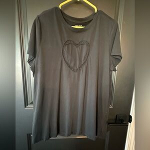 Black t-shirt with heart patch on chest.